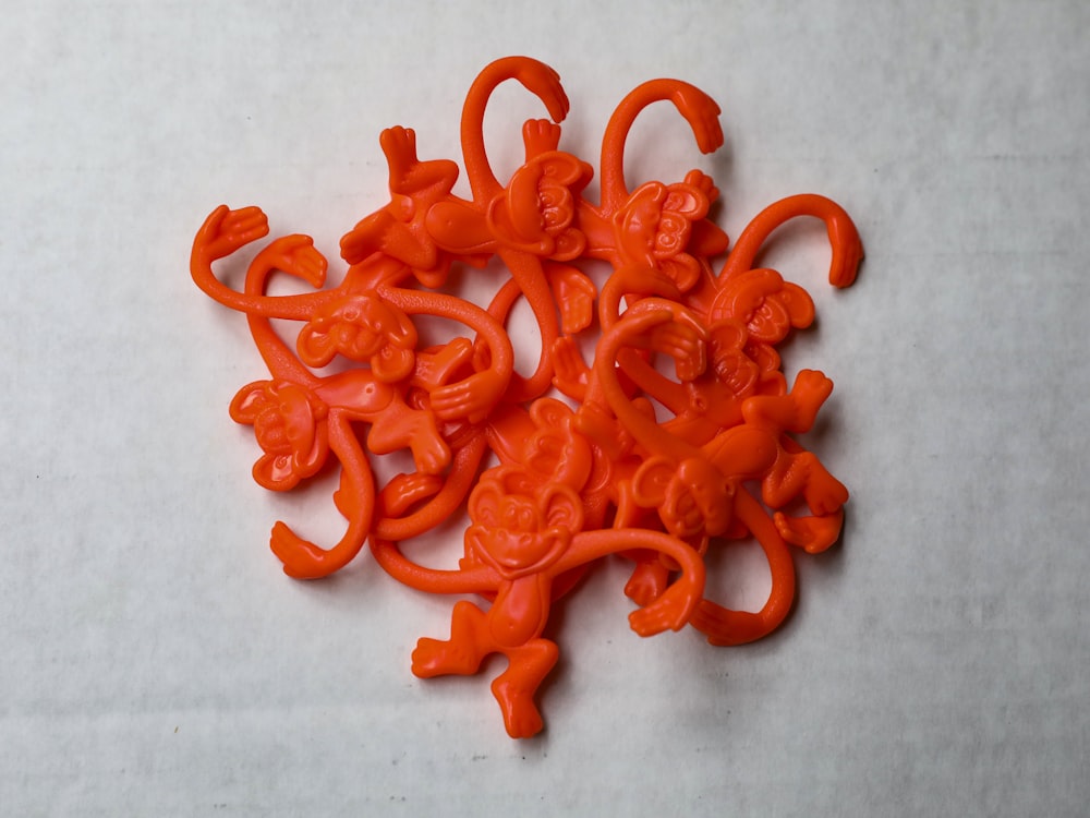 orange plastic toy on white surface