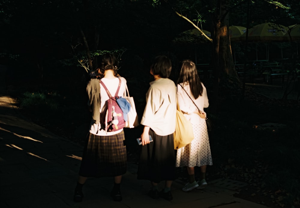 小道を歩く白いドレスを着た3人の女の子