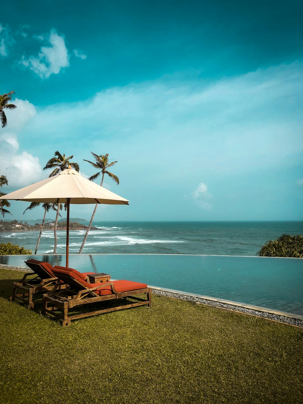 brown wooden lounge chairs on beach shore during daytime