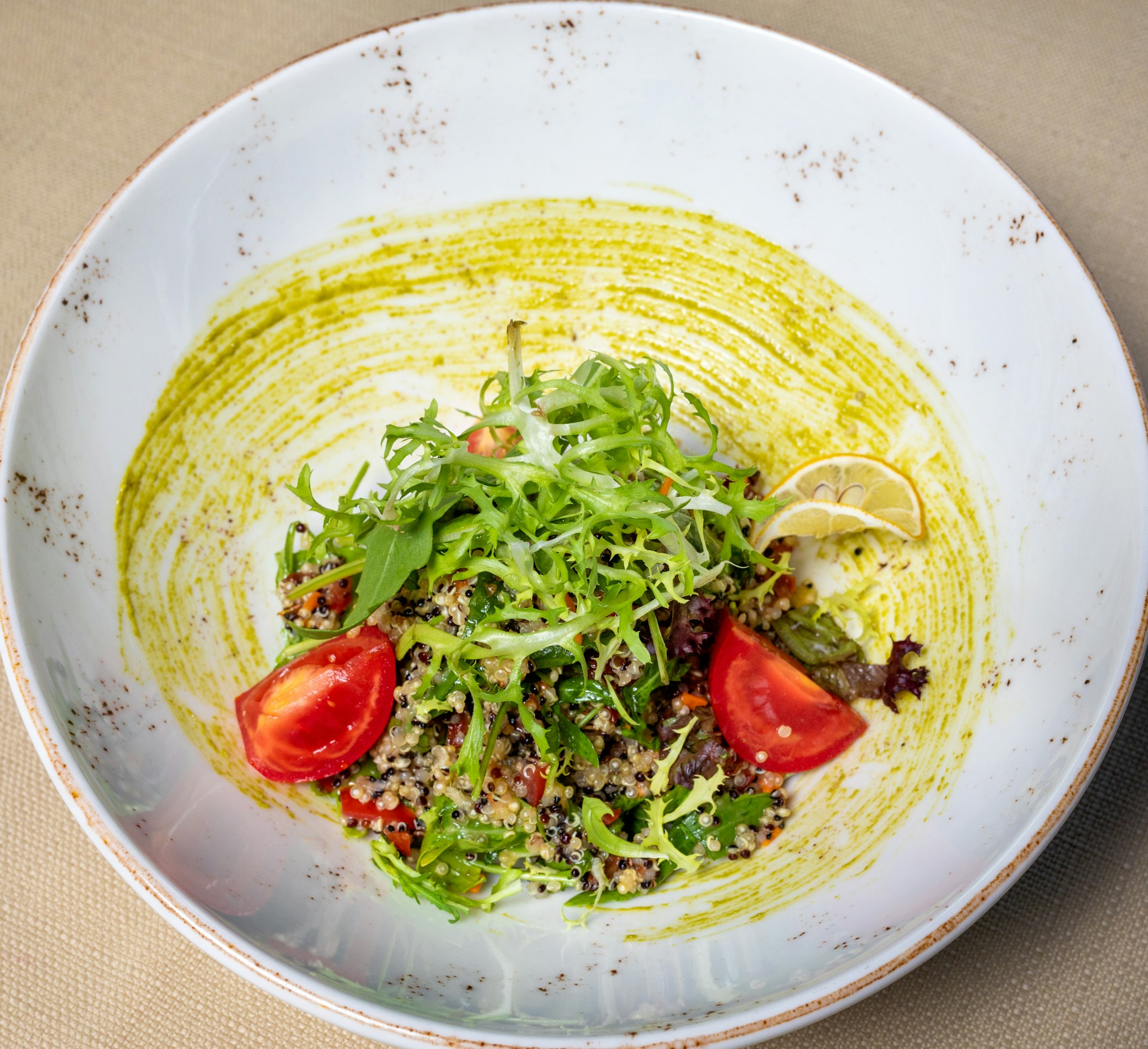 A beautifully plated quinoa salad with mixed greens, cherry tomatoes, and avocado, emphasizing nutritious eating.