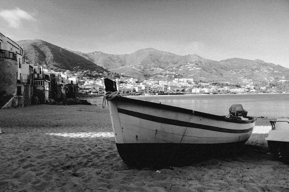 grayscale photo of a boat on a beach