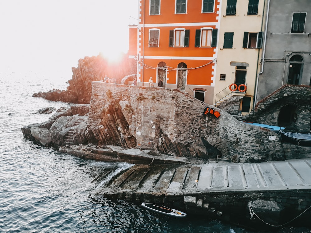 brown concrete building beside body of water during daytime