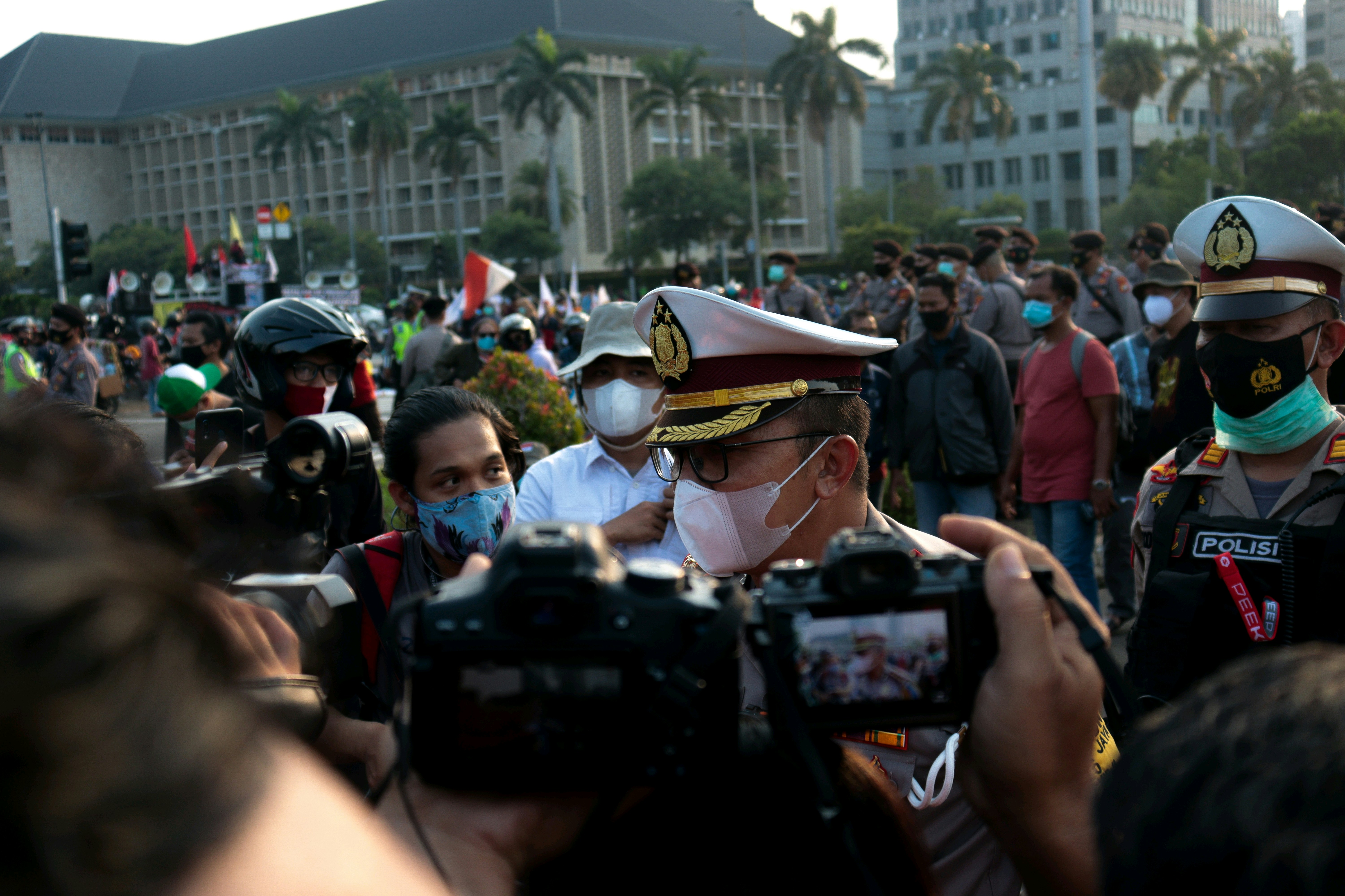 man in green and black camouflage hat holding black dslr camera during daytime