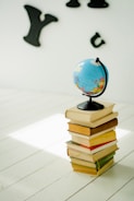 blue and yellow desk globe on yellow and white books