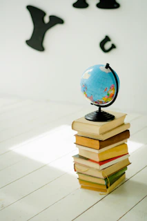 blue and yellow desk globe on yellow and white books
