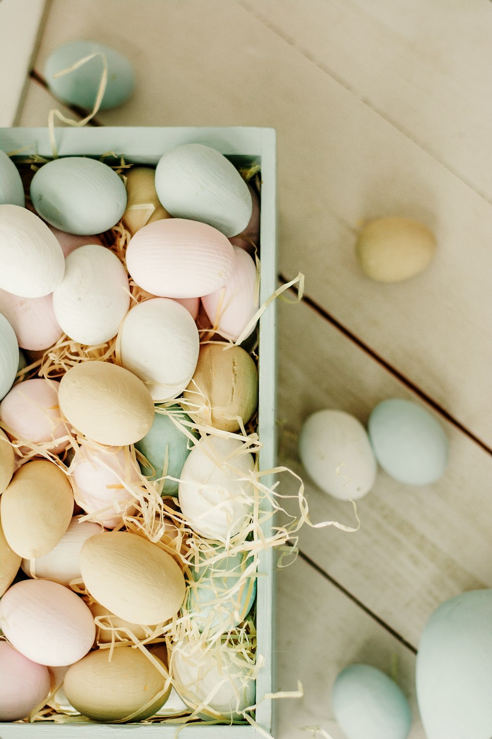 white and brown eggs on white wooden tray