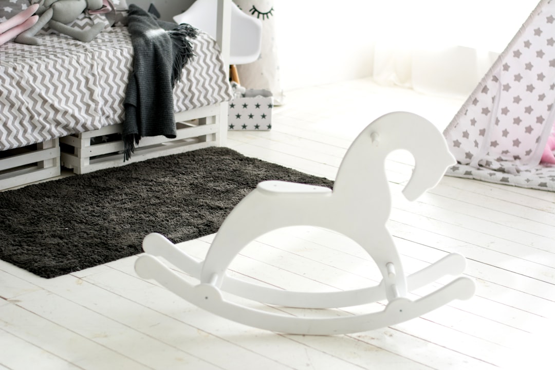 white wooden rocking chair on black and white area rug