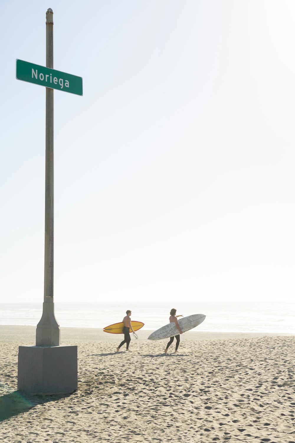 2 person sitting on bench on beach during daytime