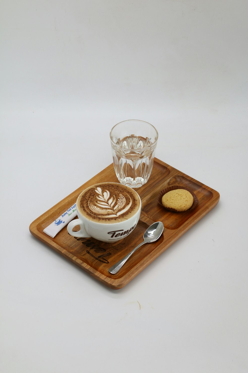 clear drinking glass on brown wooden tray