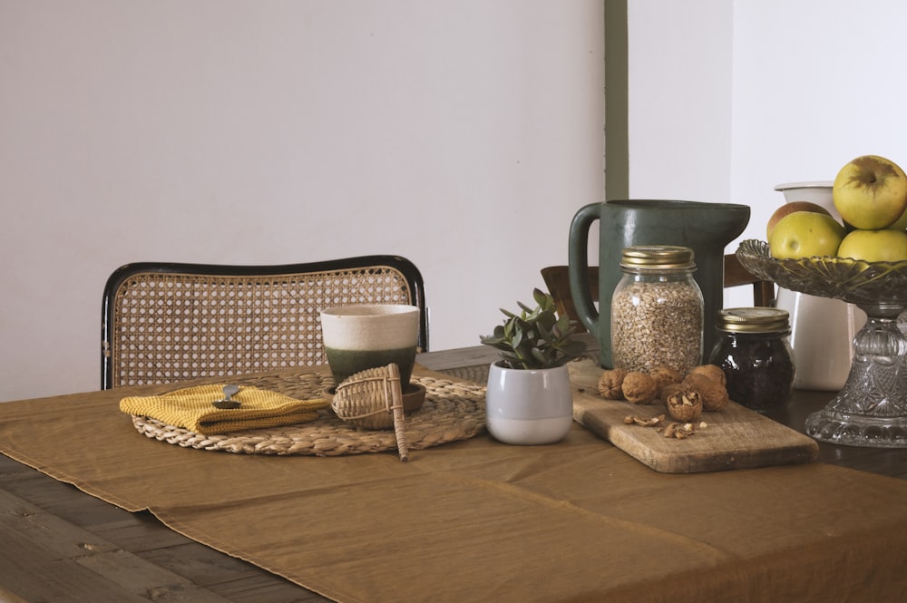 Table en bois marron avec panier et pichet en osier marron