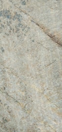 Close-up of translucent natural stone slabs with intricate veining, softly lit to highlight texture.