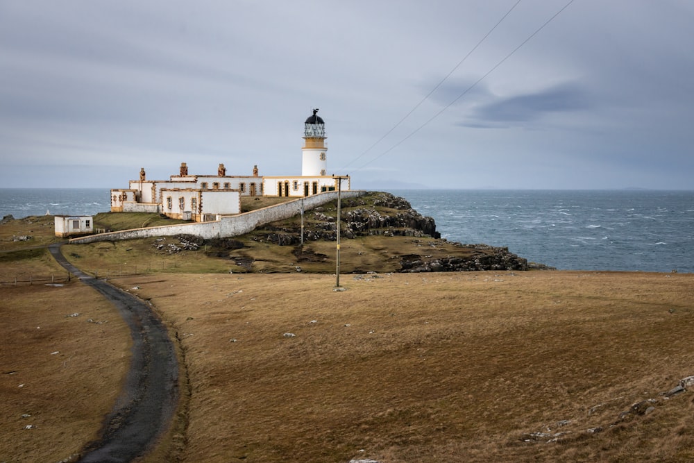 white and brown lighthouse near body of water during daytime