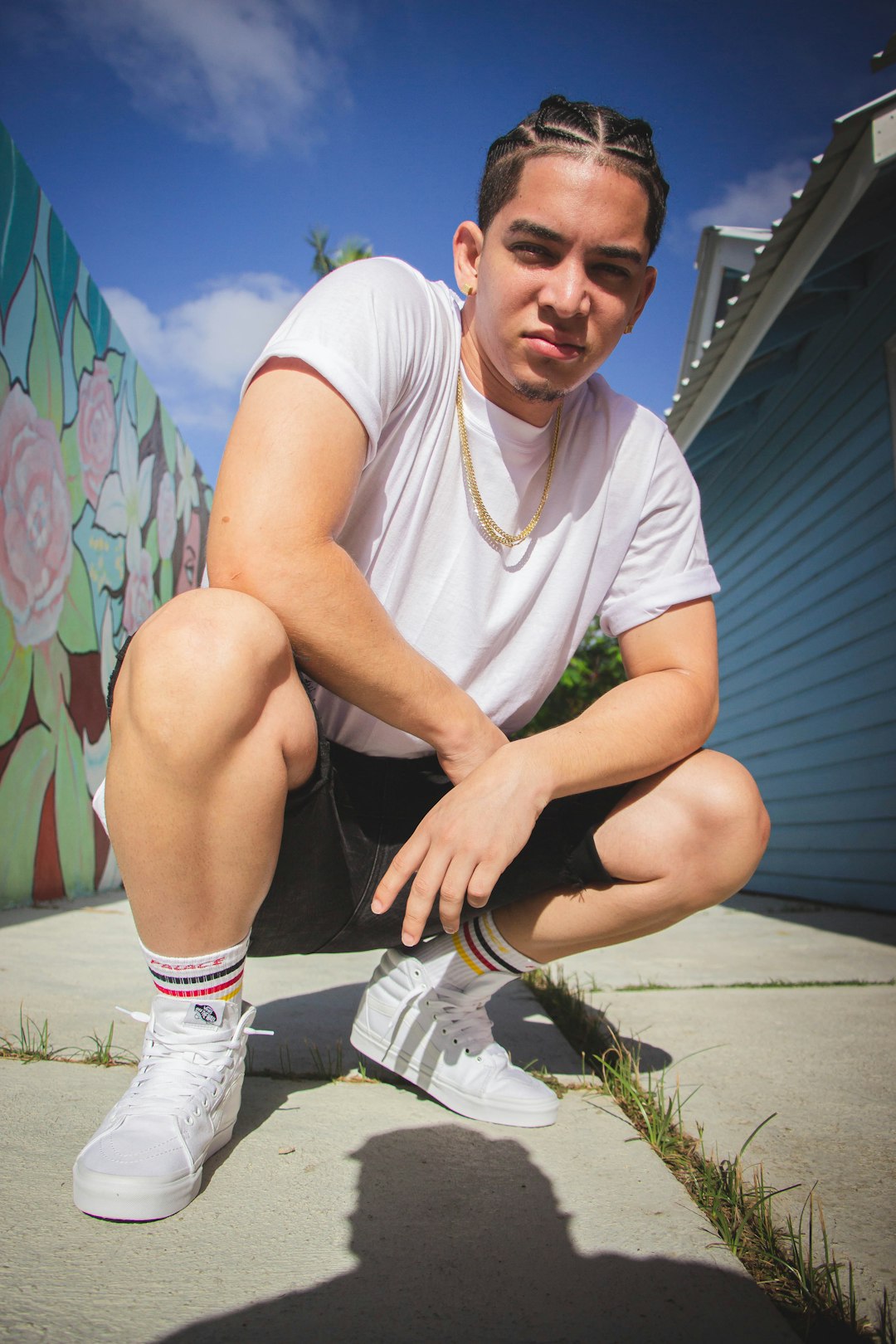 man in white crew neck t-shirt and black shorts sitting on concrete floor