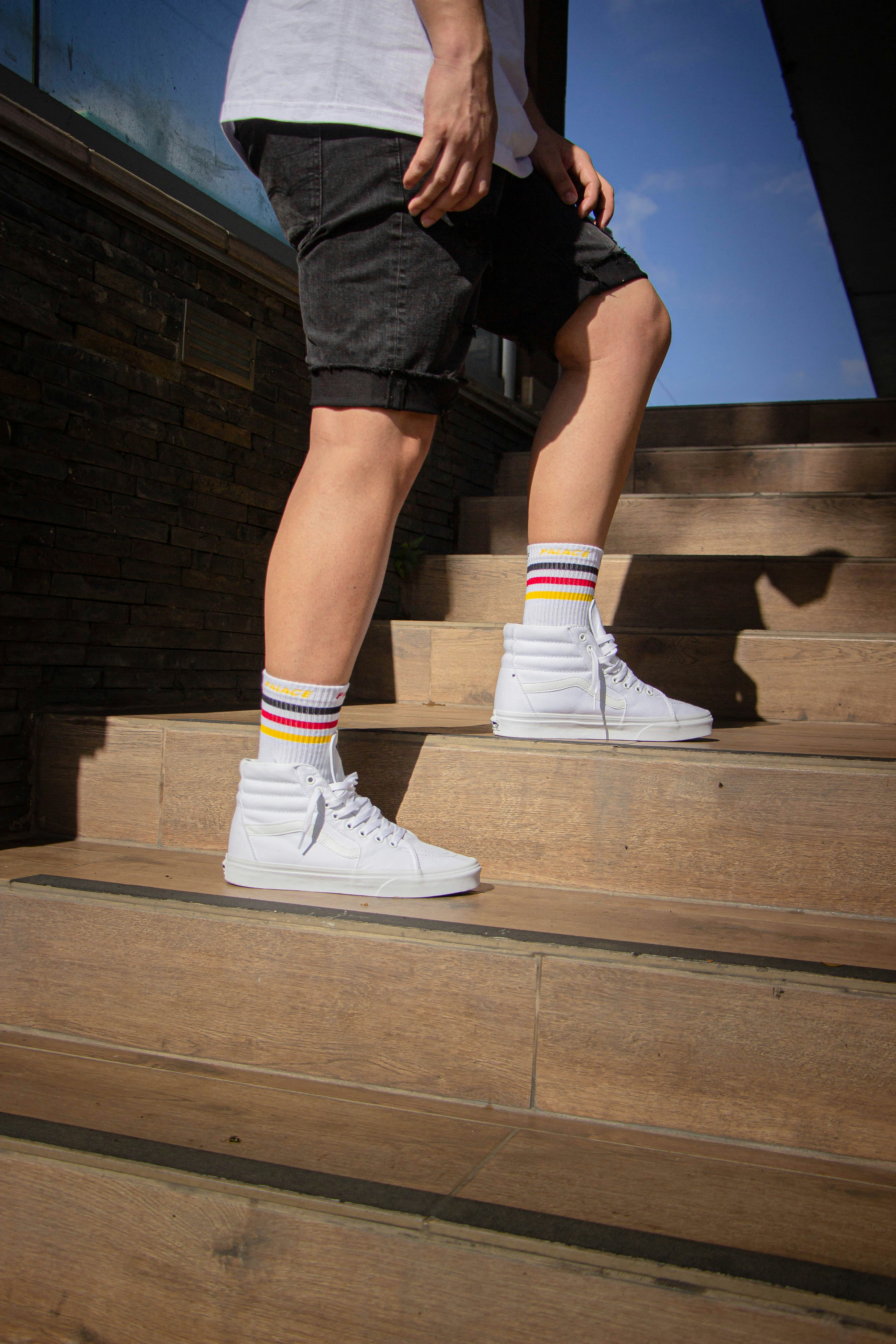 person in black shorts and white nike sneakers