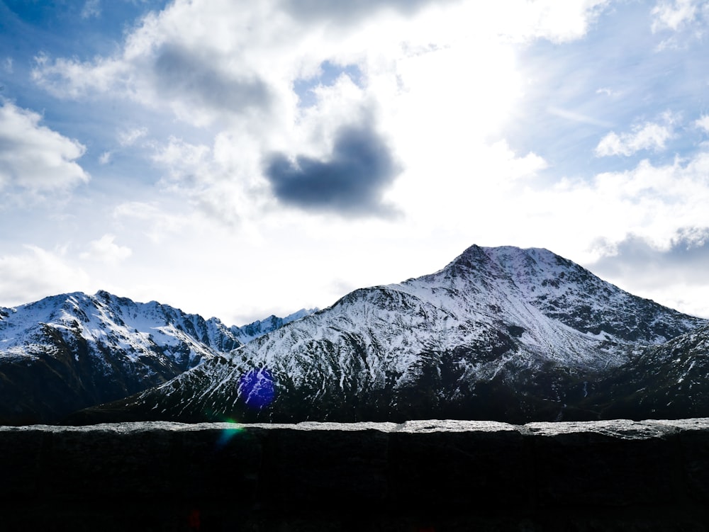 snow covered mountain under cloudy sky during daytime