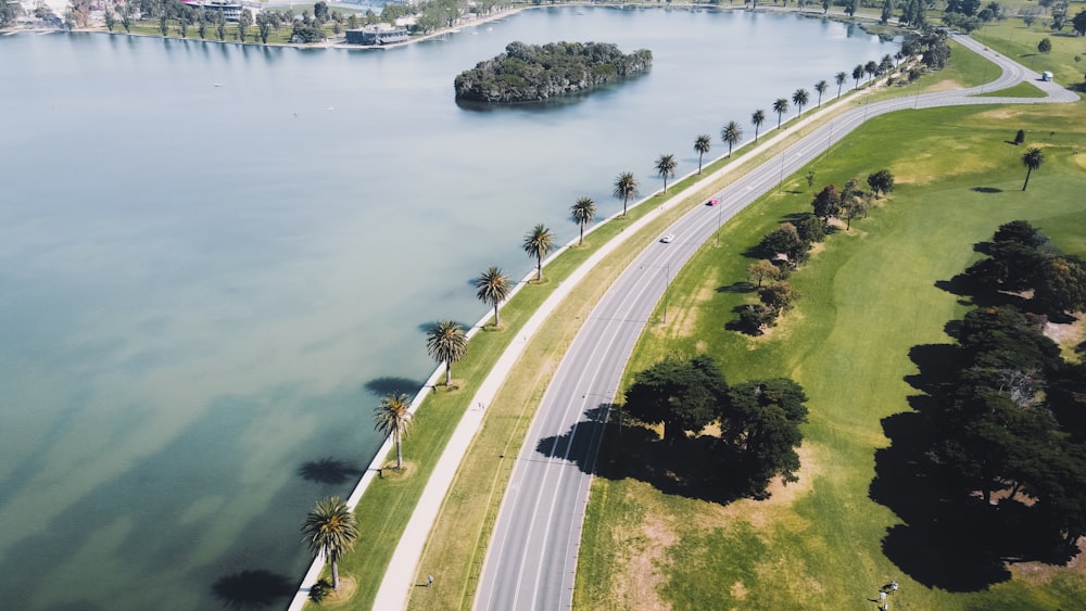 cars on road near body of water during daytime