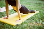 woman in black shorts and black stockings lying on yellow surfboard