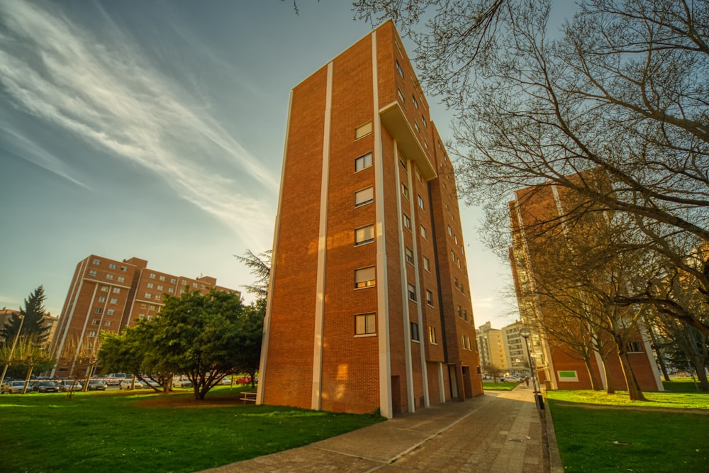 Edificio de hormigón marrón cerca de Green Grass Field durante el día