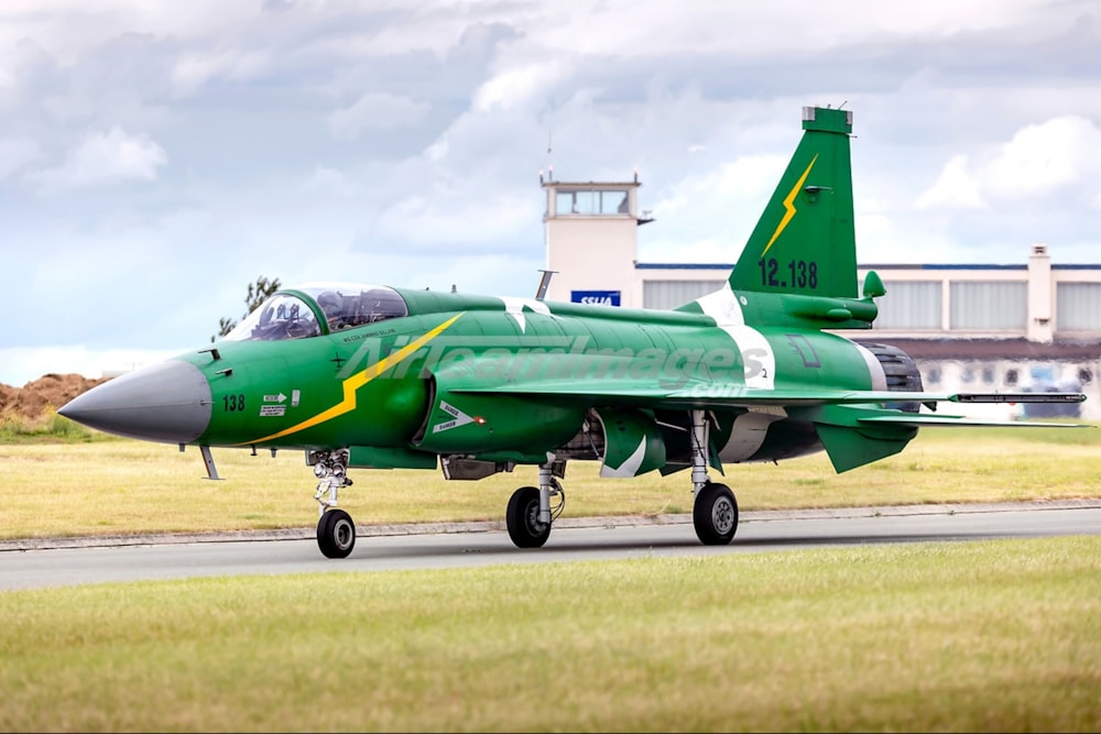 green and white jet plane on gray concrete pavement during daytime