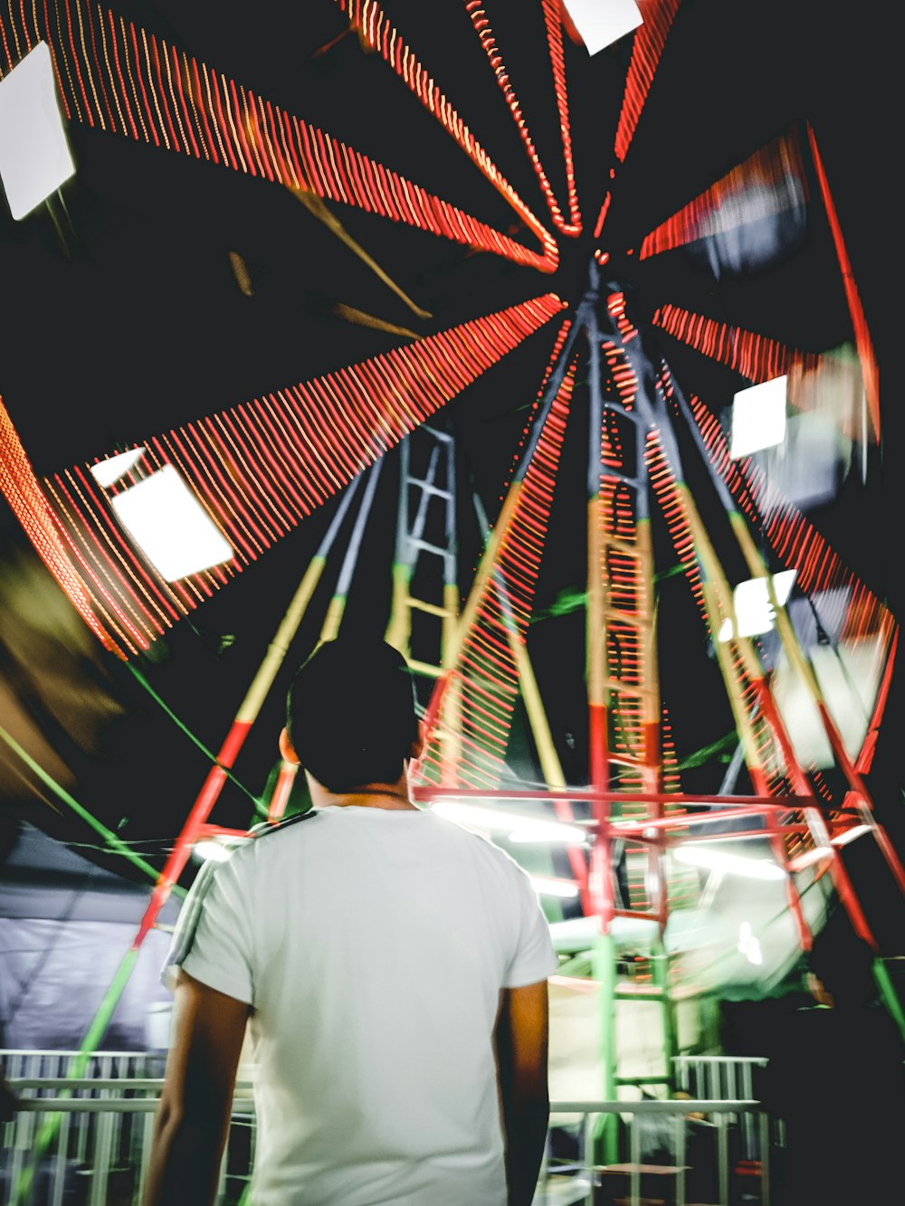 a man standing in front of a ferris wheel
