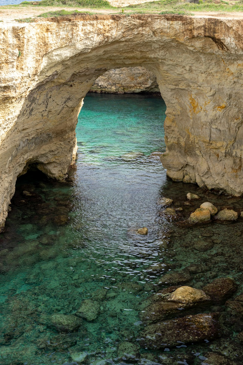 body of water between brown rock formation during daytime