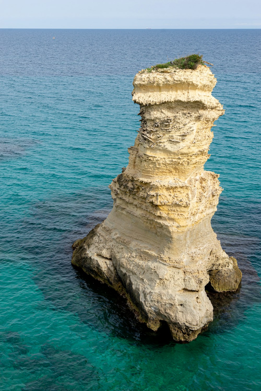 brown rock formation on blue sea during daytime