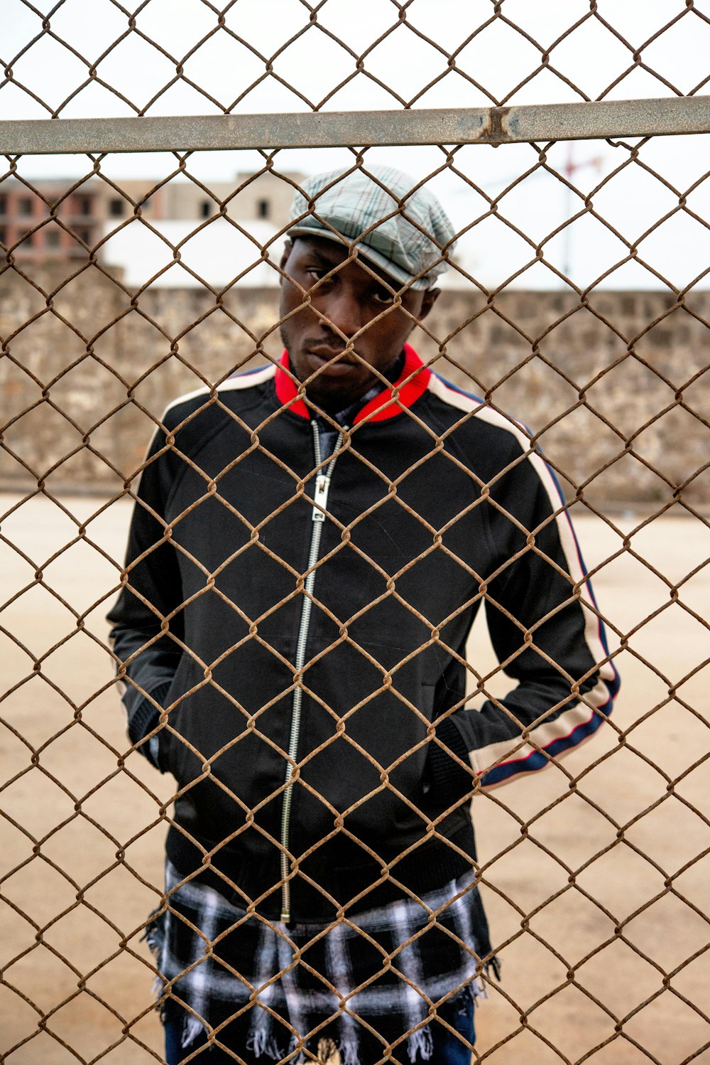 man in black and red zip up jacket standing on brown sand during daytime