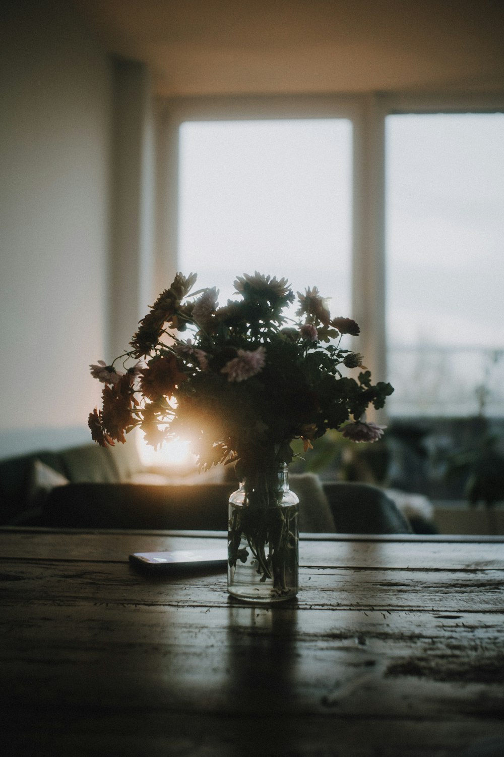 white flowers in clear glass vase on brown wooden table