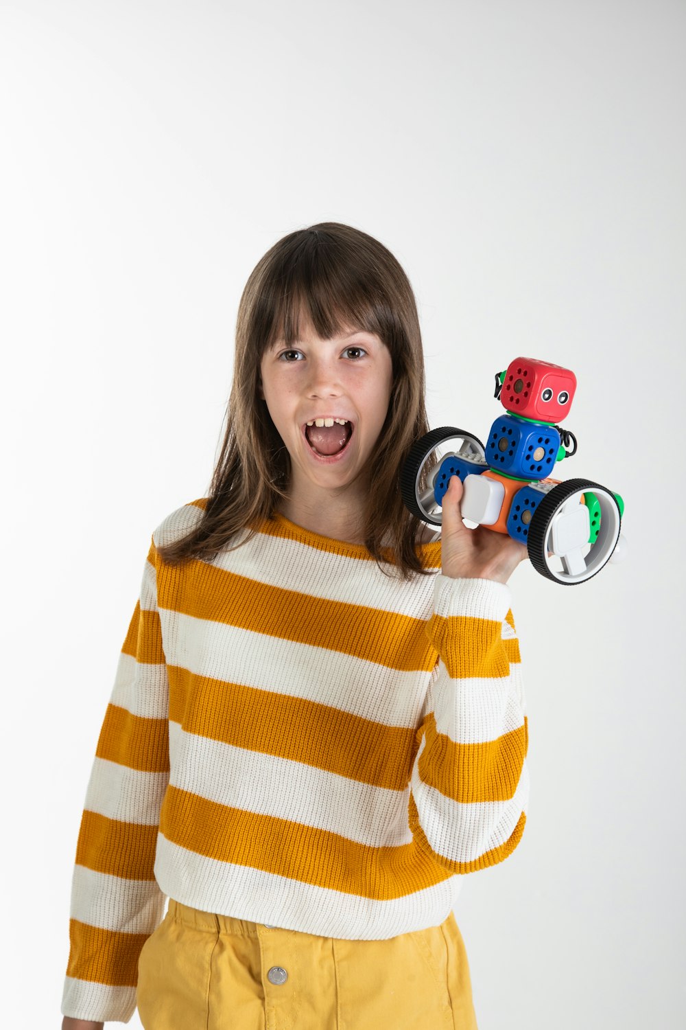 woman in yellow and white striped long sleeve shirt holding red and black toy car