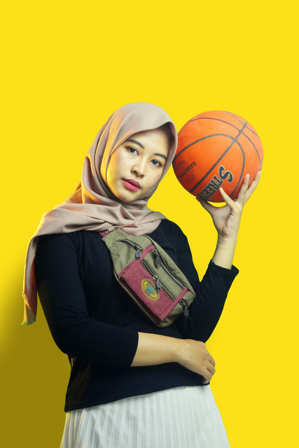 woman in brown hijab holding basketball