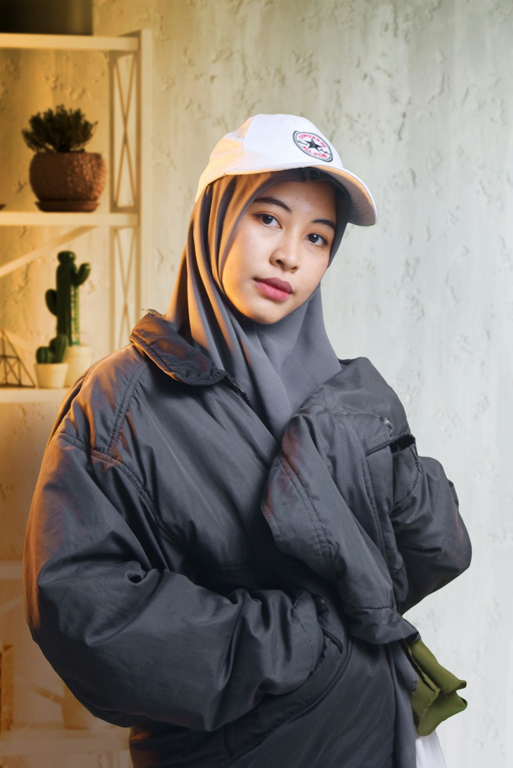 woman in black leather jacket wearing white cap