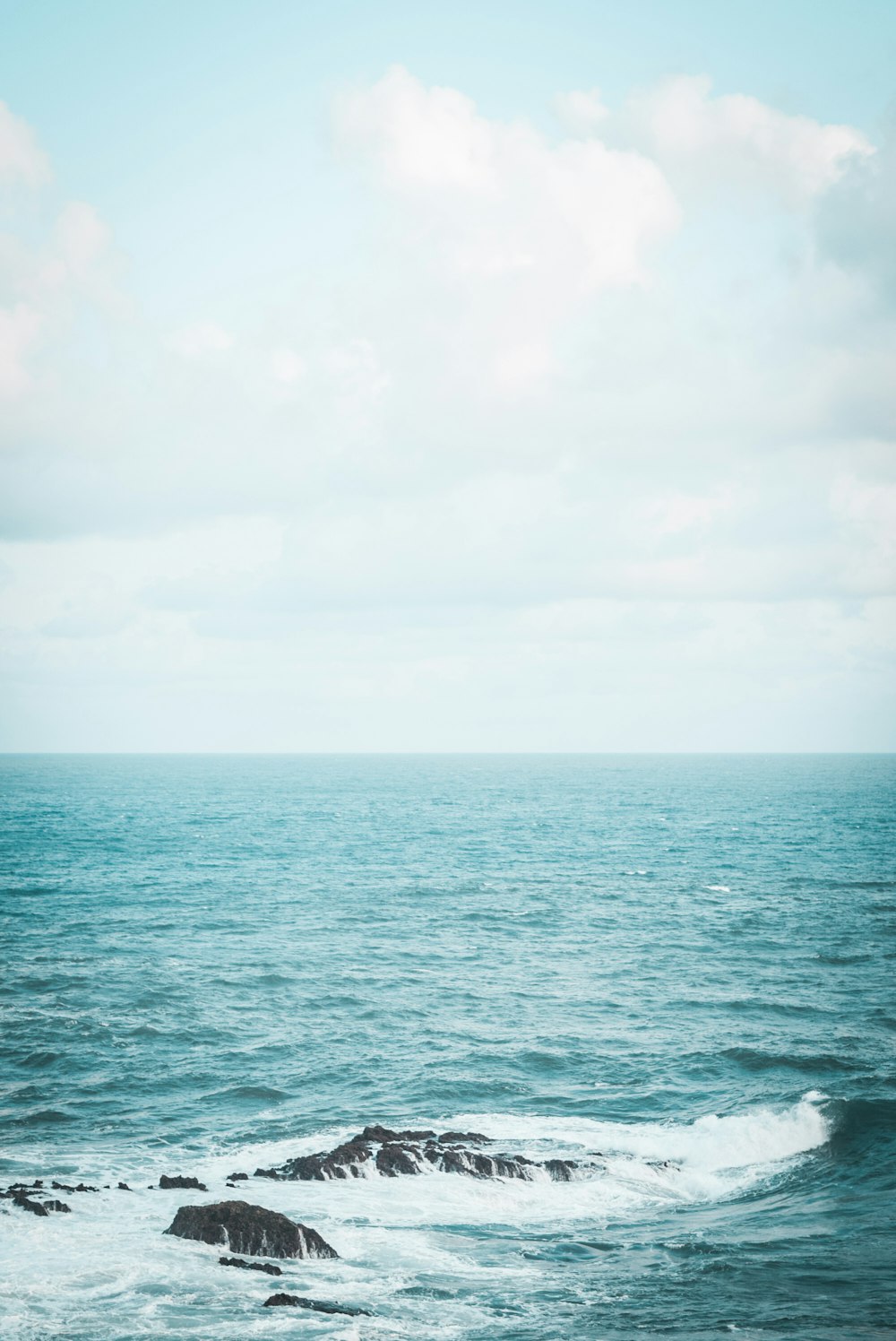 body of water under white sky during daytime