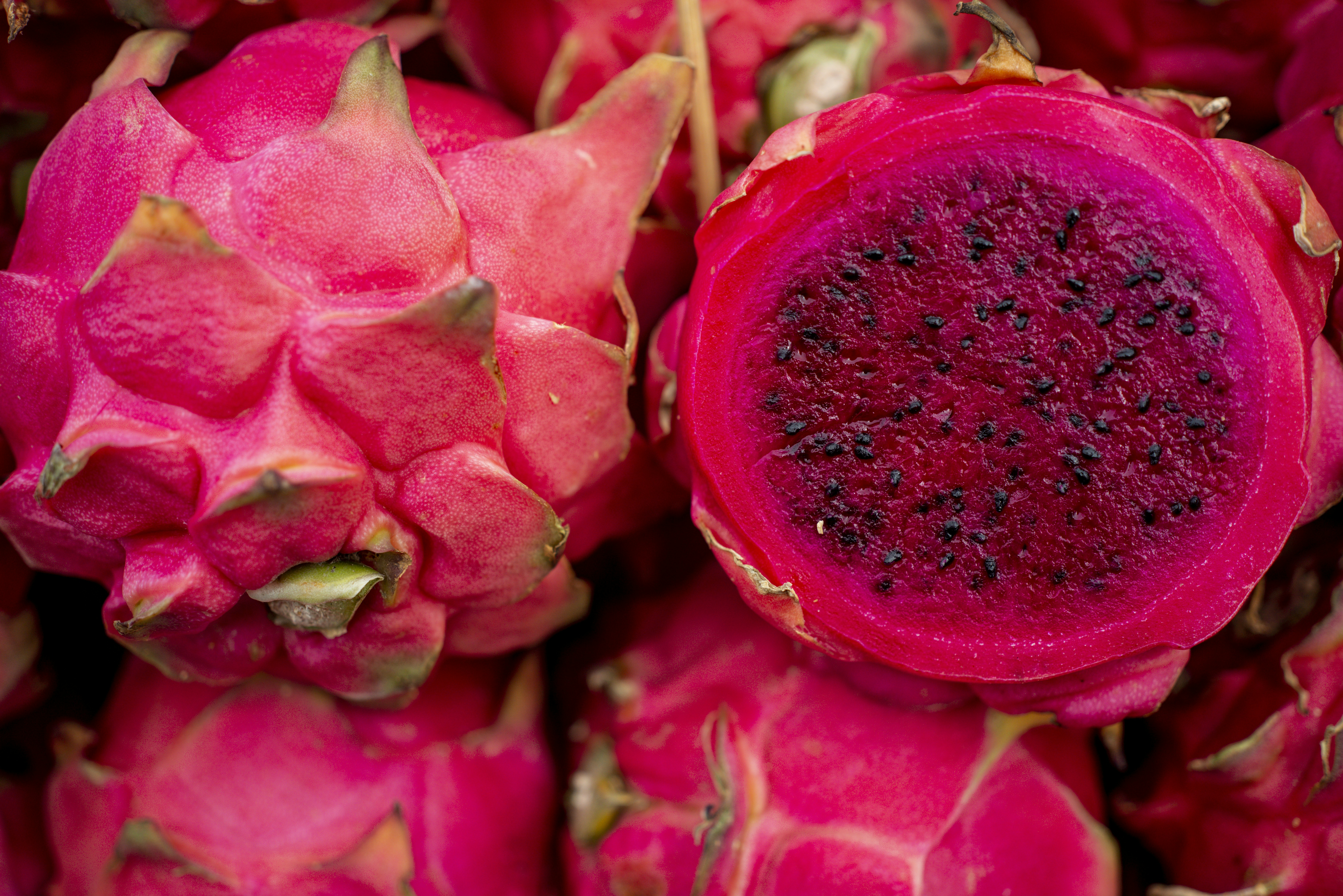 Pink dragon fruit cut open on light surface