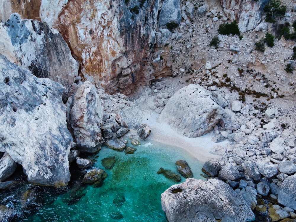 formazione rocciosa grigia accanto allo specchio d'acqua durante il giorno