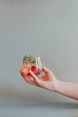 person holding white and red plastic container
