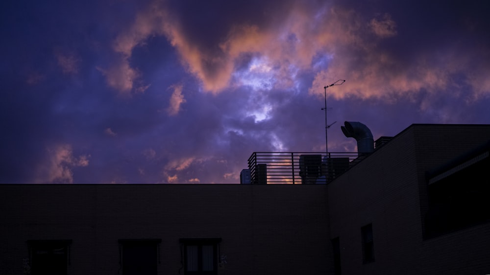 silhouette of building under cloudy sky during sunset