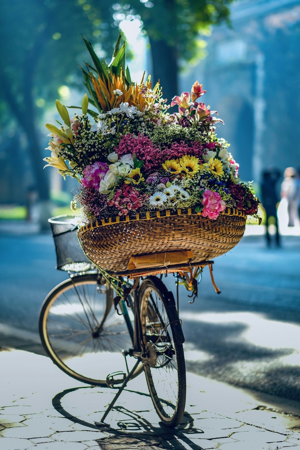 Blumen im braunen geflochtenen Korb auf dem Fahrrad