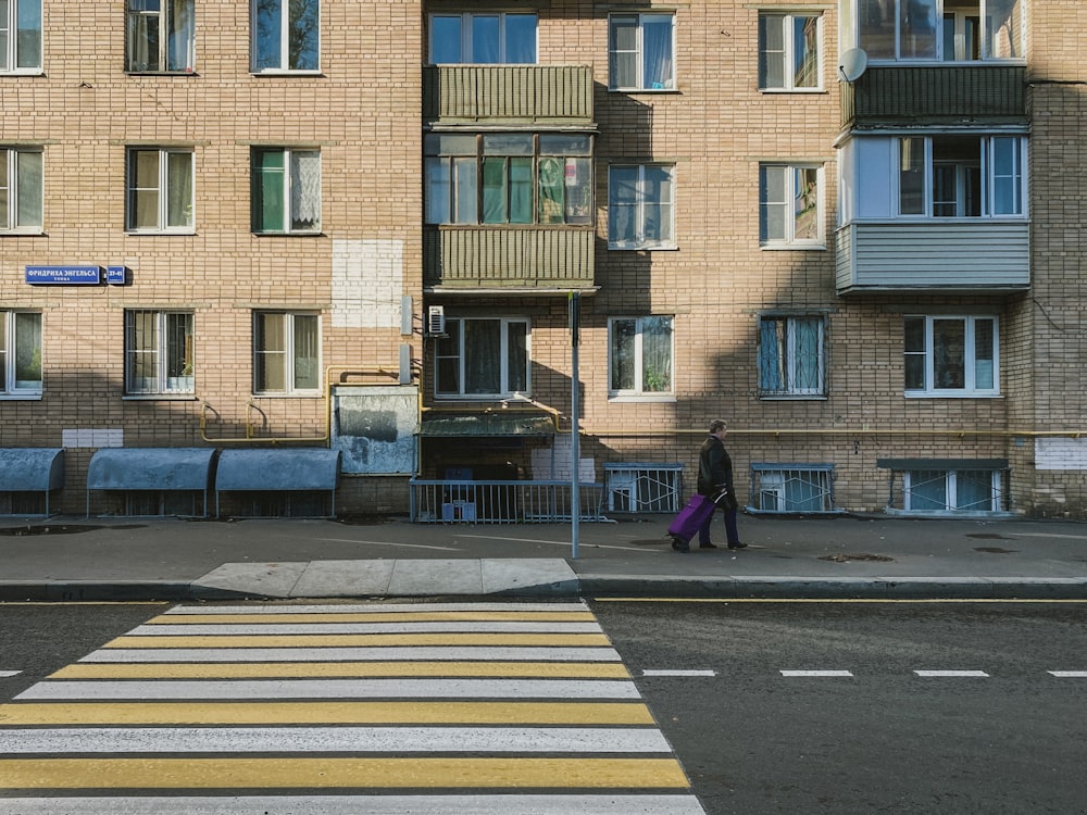 woman in black coat walking on pedestrian lane during daytime