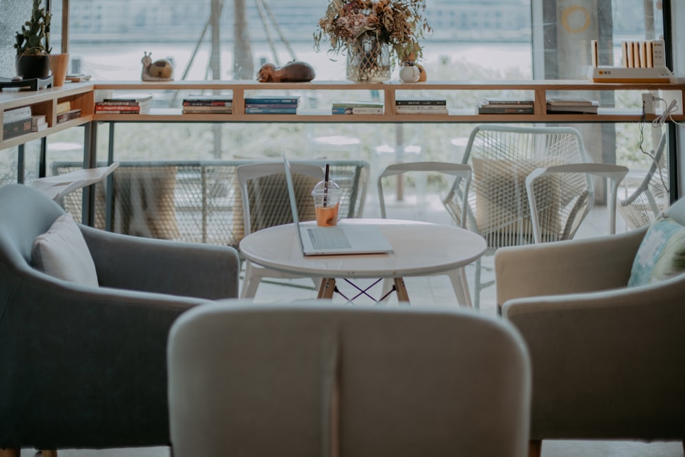 white table and chairs near glass window