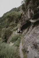 Carole walking along a scenic trail during an experiential journey, surrounded by lush greenery.