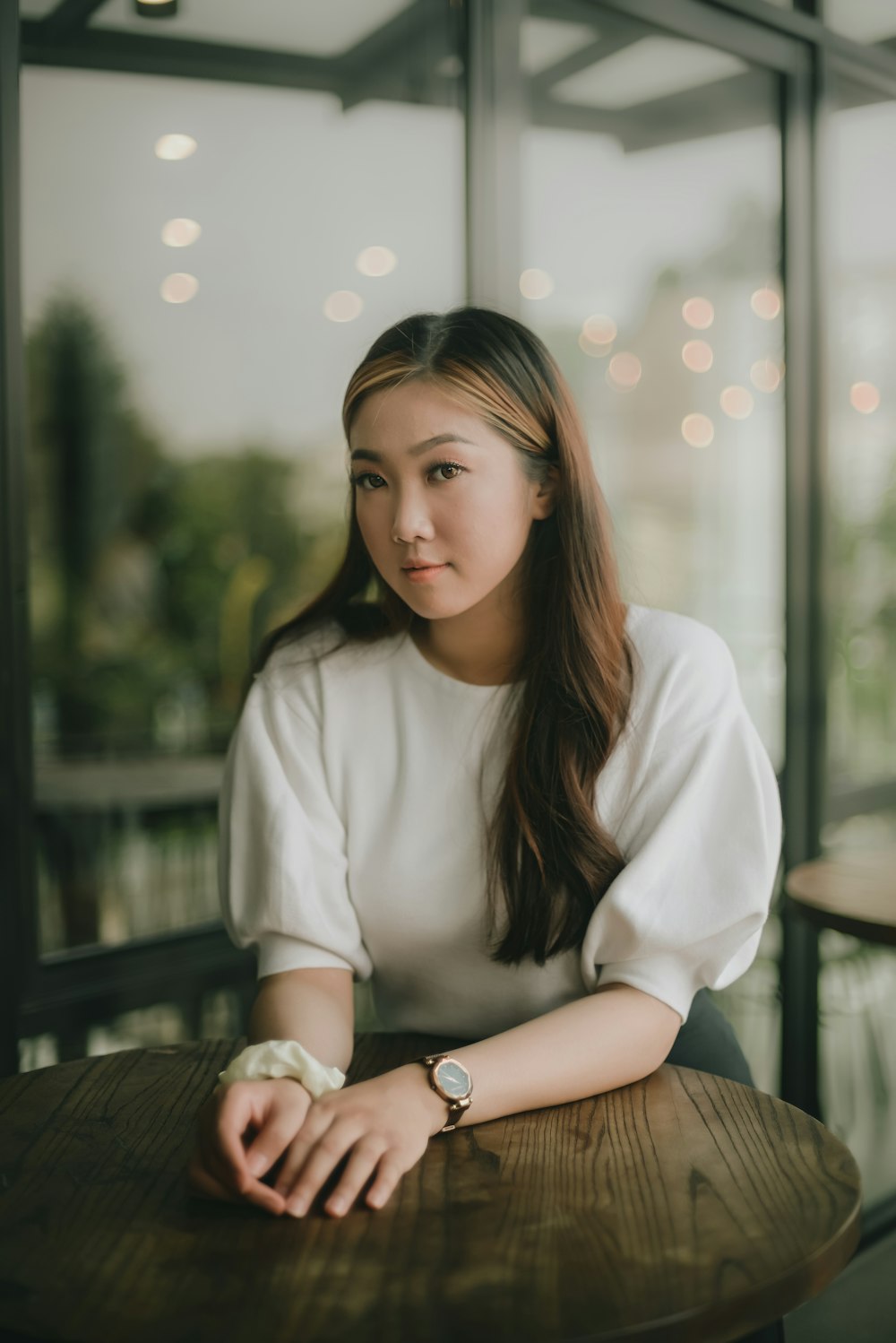 woman in white long sleeve shirt sitting on brown wooden bench