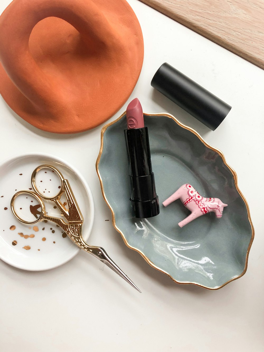 black lipstick and pink lipstick on white ceramic plate