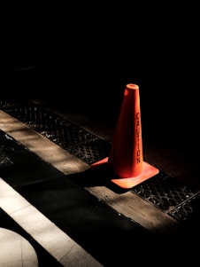 A simple construction sign with a caution cone on a clean white background.