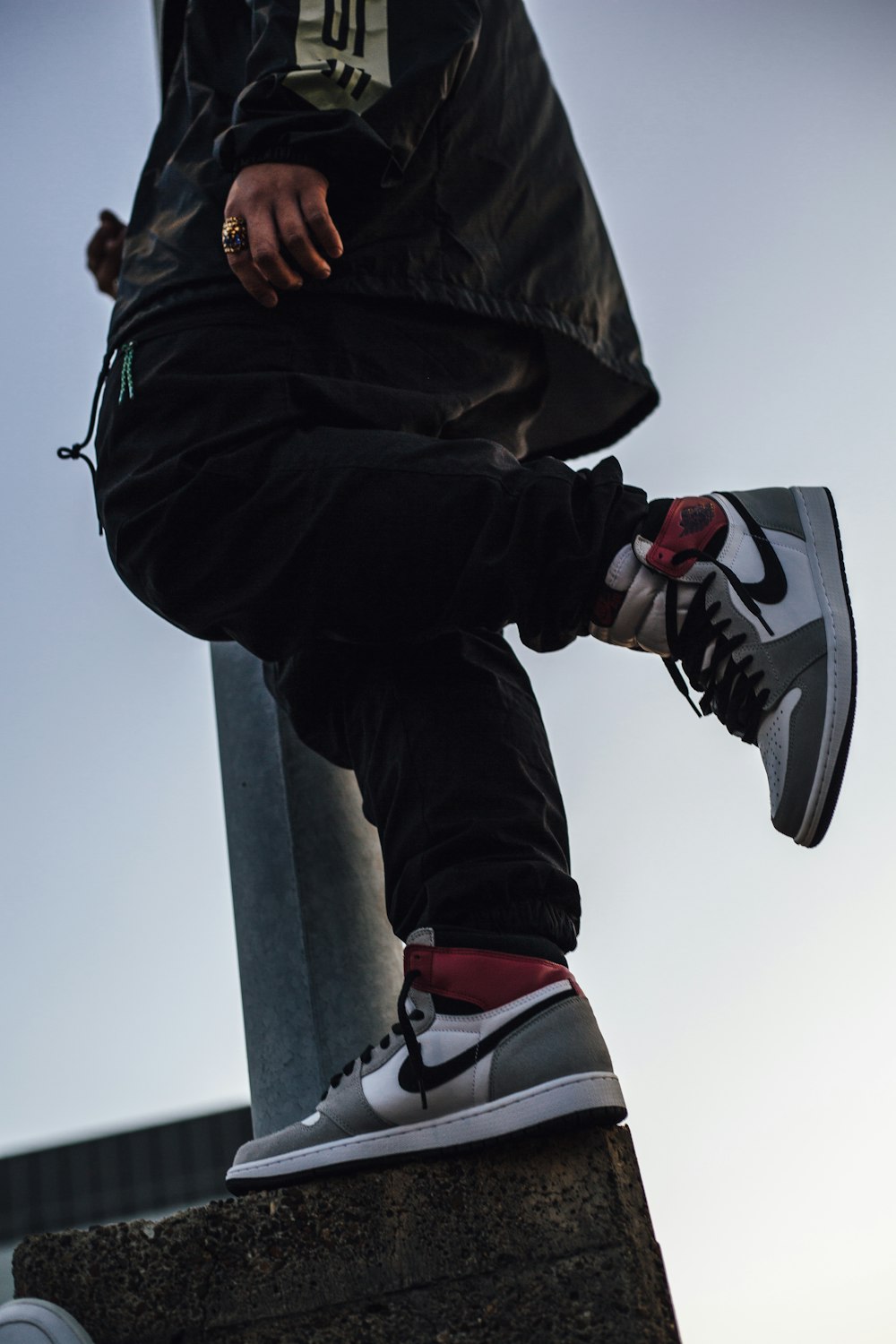 person in black pants and black and white nike sneakers