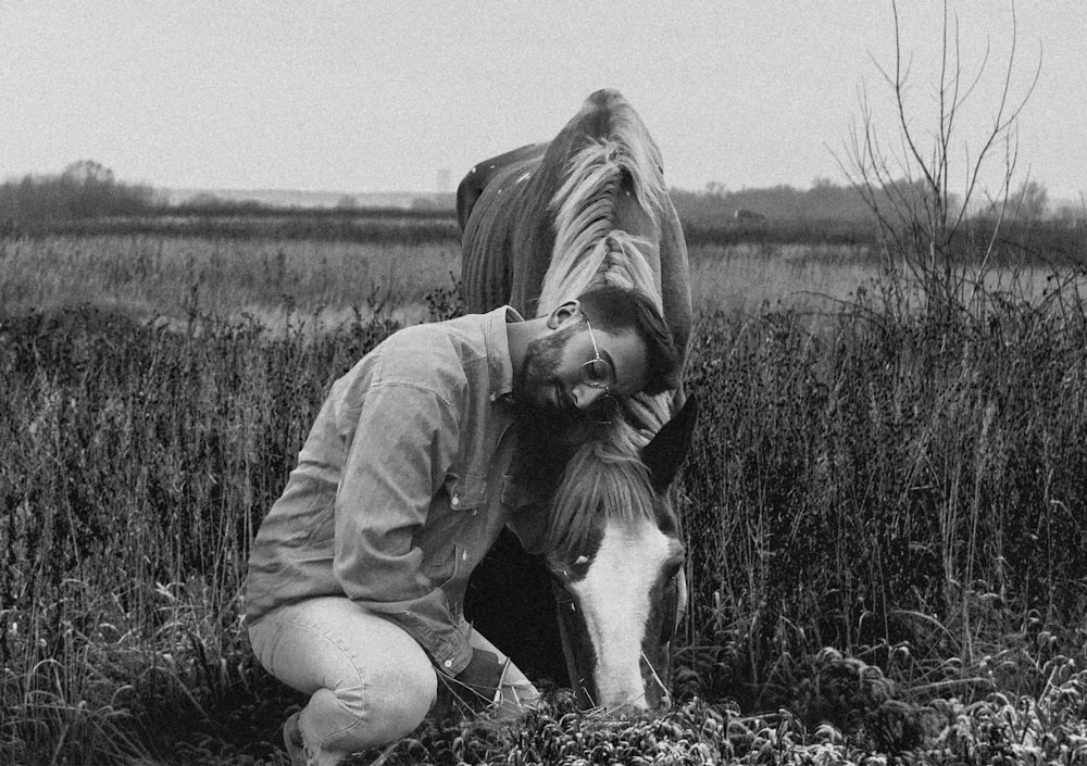 grayscale photo of woman in jacket sitting on grass field