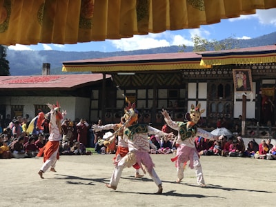 Colorful Bhutanese festival dancers in vibrant traditional attire celebrating in a mountain village.