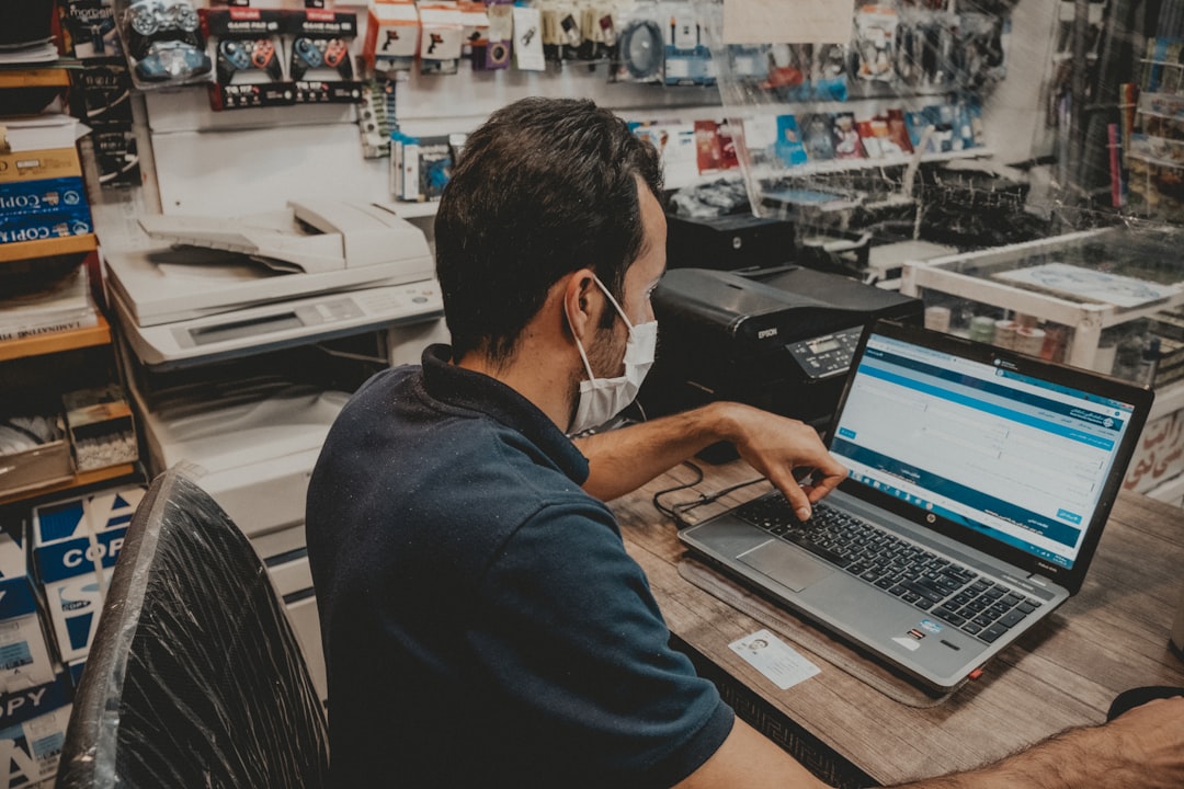 man in blue shirt using black laptop computer