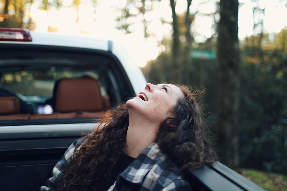a woman is sitting in the back of a truck