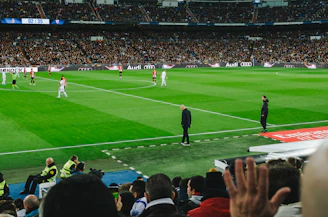 people watching soccer game during daytime