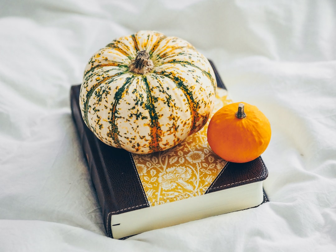 white and orange pumpkin on black book